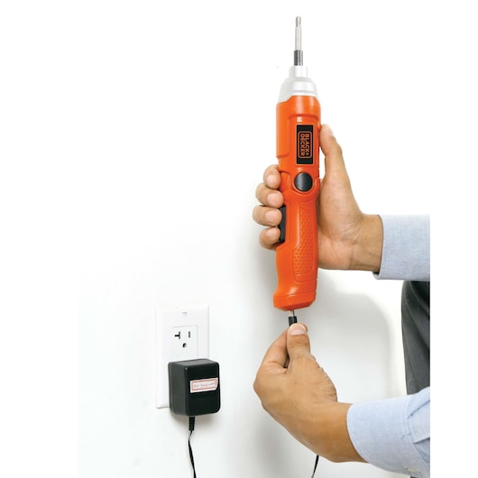 Photo of BLACKDECKER 9036 orange cordless electric screwdriver being charged with wall adapter.