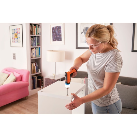 BLACKDECKER BCRTA601I cordless screwdriver used to assemble white furniture indoors.
