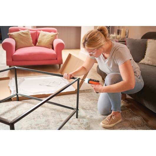 Photo of BLACKDECKER BCRTA601I cordless screwdriver used to assemble a metal table frame in a living room.