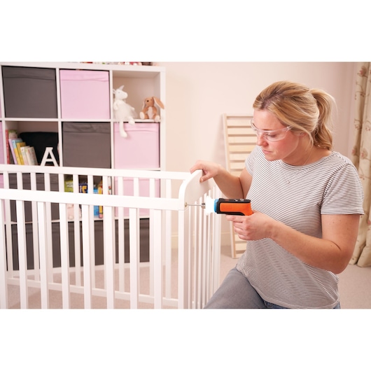 BLACKDECKER BCRTA601I cordless screwdriver used to assemble a white baby crib in a nursery.