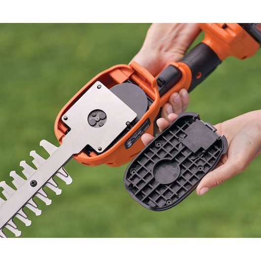 Photo of BLACKDECKER BCSS820C1 cordless shrub trimmer with blade cover removed, showing internal mechanism, outdoor setting.