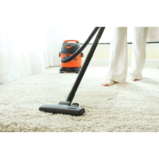 Photo of BLACKDECKER BDWD15 wet and dry vacuum cleaner in use on light carpet, low angle indoor view.