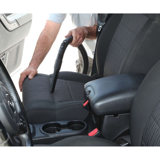 BLACKDECKER BDWD15 vacuum cleaner used to clean car seat upholstery, close-up angle.