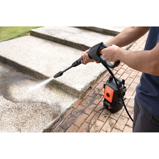 BLACKDECKER BEPW1300 pressure washer cleaning outdoor steps, photography of product in use.