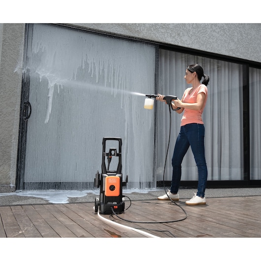 BLACKDECKER BEPW1520L pressure washer used to clean glass door outdoors, photography.
