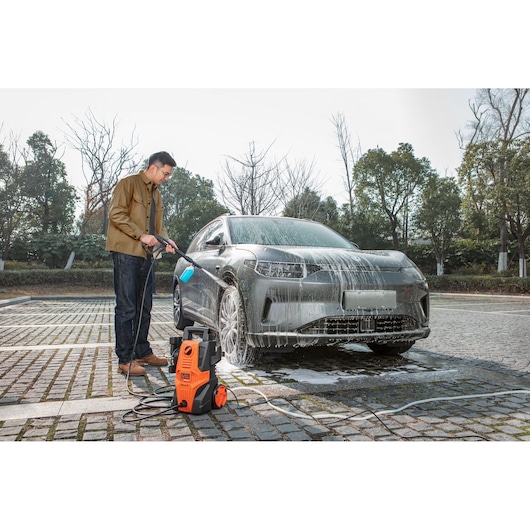 BLACKDECKER BEPWB1740 pressure washer used to clean a car with soap outdoors.