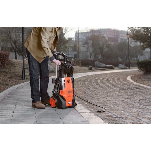 BLACKDECKER BEPWB2400 pressure washer on pavement with hose, outdoor setting, product in use.