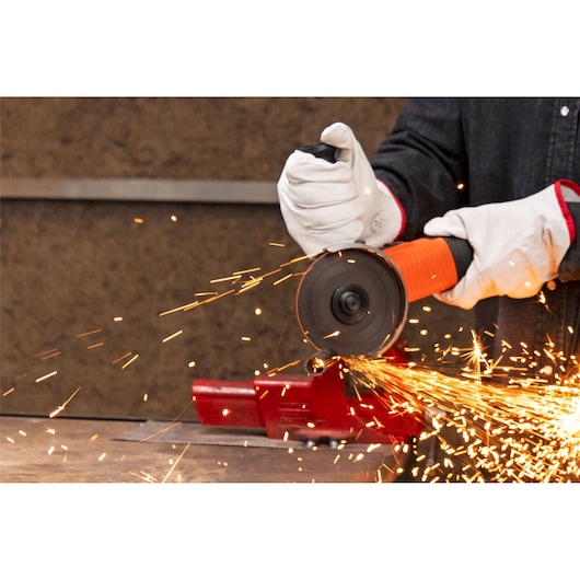 BLACKDECKER G720X angle grinder in use, orange and black design, cutting metal with visible sparks.