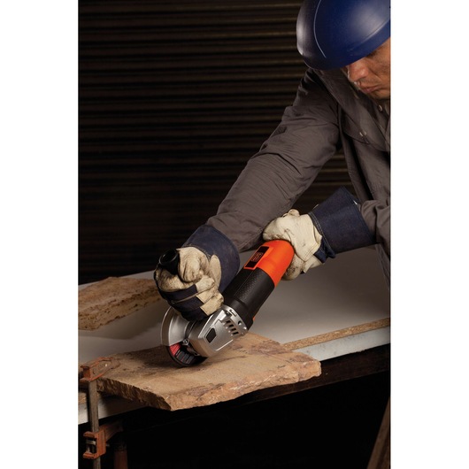 BLACKDECKER G720 angle grinder in use, cutting stone slab, close-up, orange and black body.