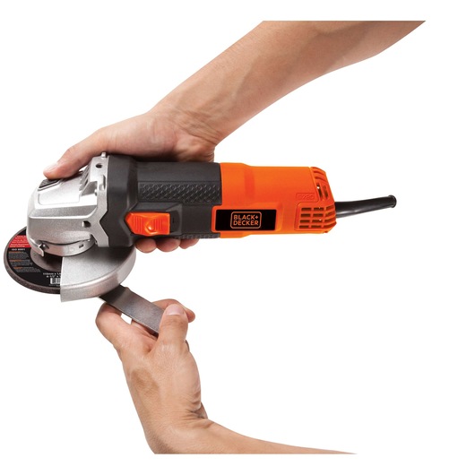 Photo of BLACK+DECKER G720 angle grinder with orange and black body, shown in hand on white background.