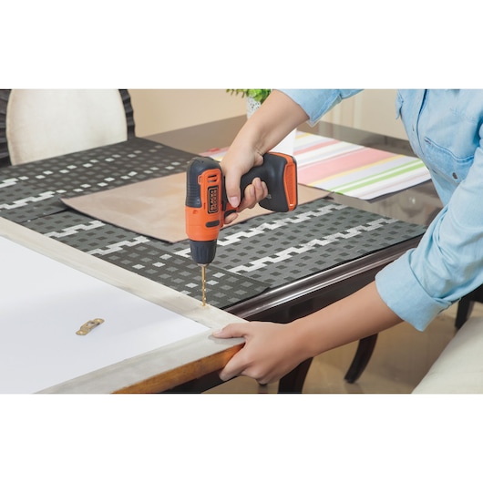 Photo of BLACKDECKER LD12S cordless drill used to drill into a wooden frame on a table indoors.
