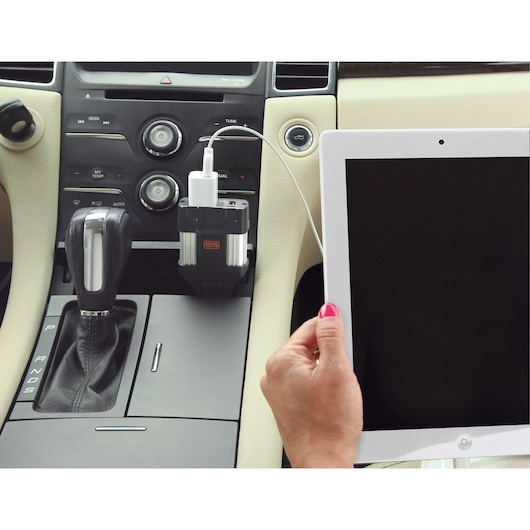 BLACKDECKER PI100LA power inverter charging a tablet in a car interior.