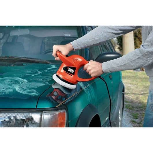 Photo of BLACK+DECKER WP900 car polisher in use on a green vehicle hood.