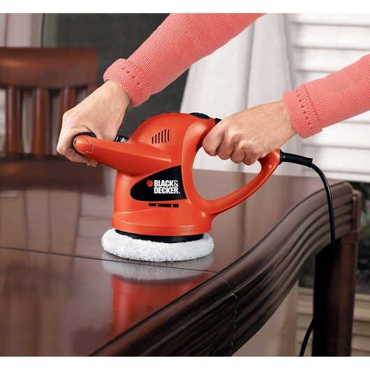 Photo of BLACKDECKER WP900 orange polisher being used to polish a wooden table.
