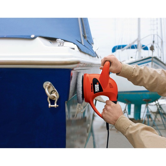 BLACK+DECKER WP900 polisher being used on a boat hull outdoors.
