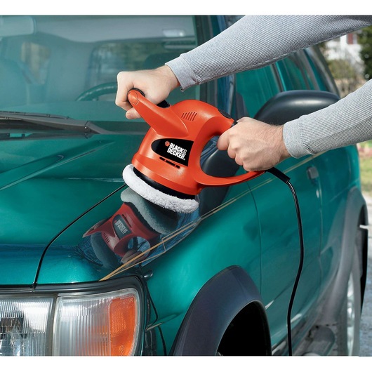 BLACK+DECKER WP900 orange handheld polisher in use on car hood.